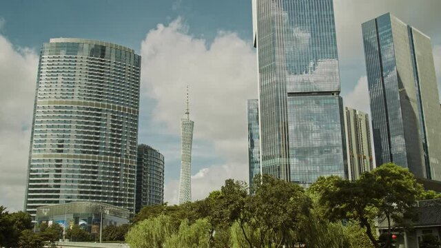 Guangzhou CBD and Canton tower in early morning. Big moving clouds reflection in office buildings. Time lapse