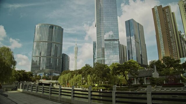 Guangzhou CBD and Canton tower in early morning. Big moving clouds reflection in office buildings. Time lapse