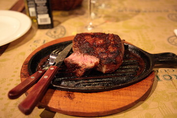 Grilled Argentina rib eye beef steak meat on table at a traditional Argentinean restaurant, in Buenos Aires, Argentina.