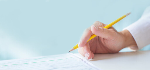 high school,university student study.hands holding pencil writing paper answer sheet.sitting lecture chair taking final exam attending in examination classroom.concept scholarship for education abroad