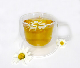 tea with chamomile in a glass cup on a white background, concept of ecology, medicinal tea, summer