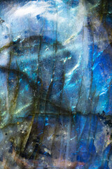Extreme macro photo of a luminous and iridescent blue labradorite stone.  The black lines give it a surreal mountain landscape look.  
