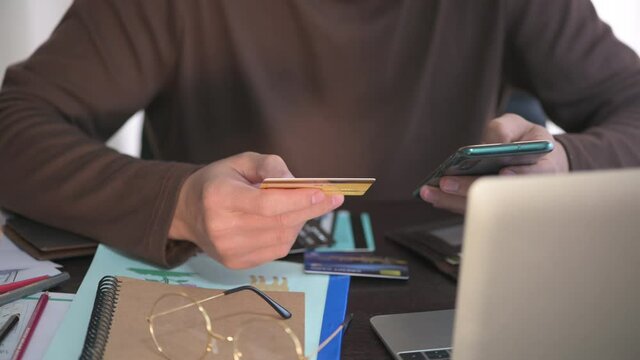 Man typing credit card CVV number for paying with credit card on tablet at home office shopping, banking, home and lifestyle concept.