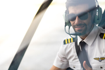 Portrait of commercial pilot in uniform sitting inside helicopter cabin. © NVB Stocker