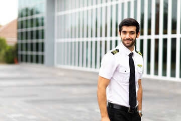 Portrait of helicopter pilot in uniform walk and standing outside with private helicopter background