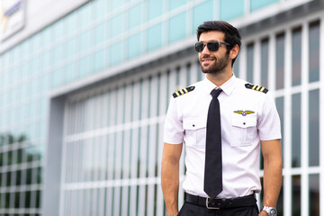 Portrait of helicopter pilot in uniform walk and standing outside with private helicopter background © NVB Stocker