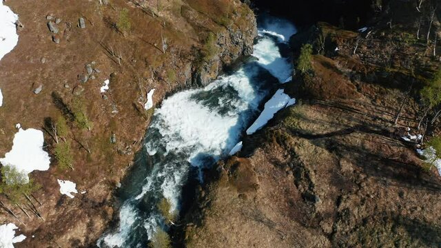 Aerial view tilting towards rapids, high up in Rotsundelv area, in the Lyngen alps, sunny summer day, in North Norway - tilt down, drone shot