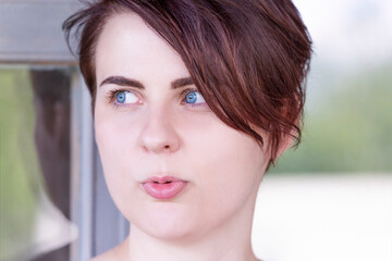 Naklejka premium Portrait of a girl with blue eyes, wide brown eyebrows and short hair