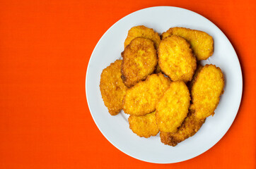 Panamanian style sweet corn fritters on orange background