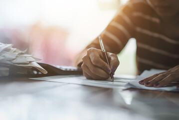 Woman hand pointing on household bills on paper close up.