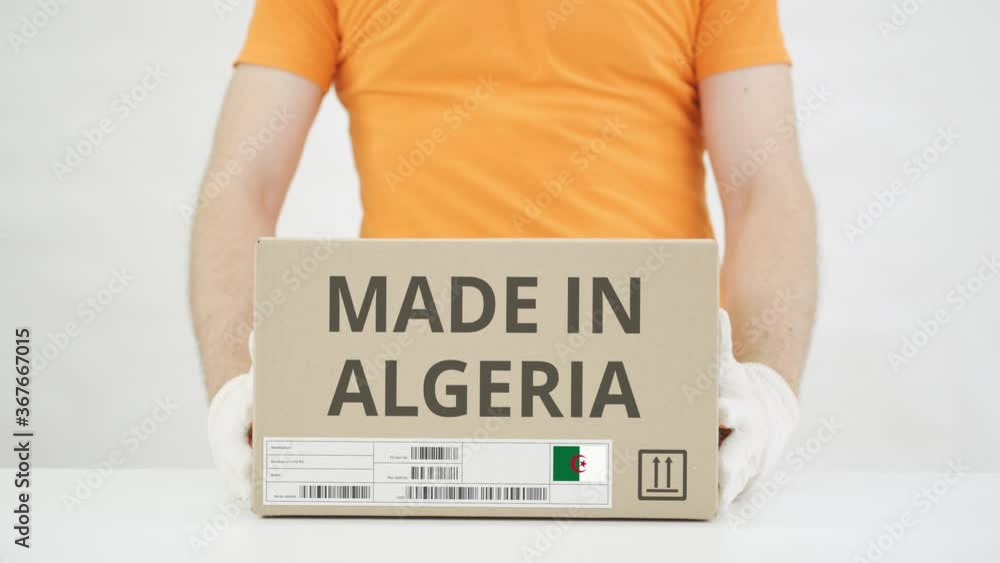 Poster man puts cardboard box with made in algeria text on the table