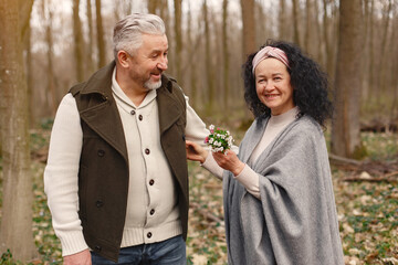 Seniors in a forest. People walks. Family with spring's flowers.