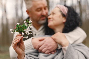 Fototapeta premium Seniors in a forest. People walks. Family with spring's flowers.