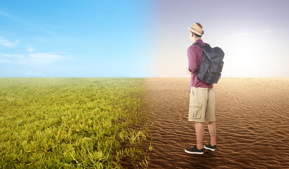 Asian man with backpack looking at the difference from drought ground and fertile soil on the field