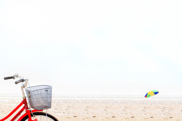 Colorful beach umbrella and bike on the sandy beach