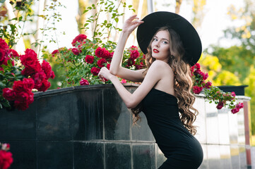 Ukrainian girl in a black dress outdoors in a hat