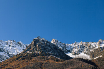 Obraz premium Wallpapers of mountains. Big rocks, glaciers and amazing cloud are all beautiful nature of Caucasus. Dombay, Karachay-Cherkessia, Russia.