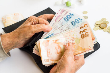 Hand of old person  from black counting money on  wallet at white background,close up.