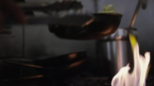 Chef flipping food in saucepan