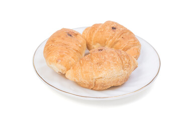 Three small croissants on a white plate on a blue background.