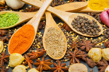 Essential spices for cooking in wooden spoons