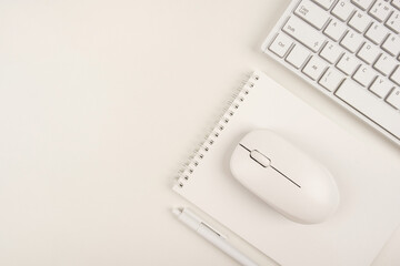 Top view of a writing desk. Minimalistic business concept, copy space. Office workplace on a white background with a keyboard, computer mouse and blank notepad.