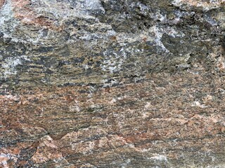 Background texture: the structure of a large stone. Granite boulder close up. Irregularities and cracks in the stone rock. Concept - stone, hardness
