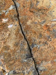 Background texture: the structure of a large stone. Granite boulder close up. Irregularities and cracks in the stone rock. Concept - stone, hardness