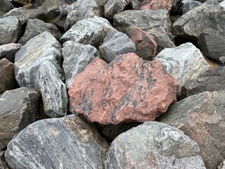 Background texture: many large stones of different shapes. A pile of granite boulders. Concept - stone, hardness, foundation