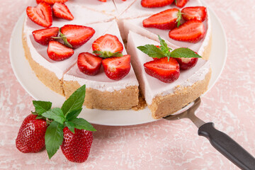 Sweet breakfast, delicious cheesecake with fresh strawberries and mint, homemade recipe without baking, on a pink stone table. Copy space.