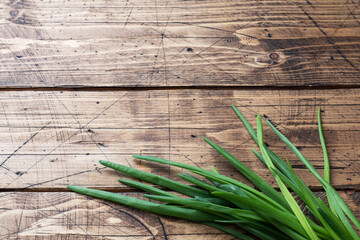 Green onions or shallots on a wooden background with copy space.