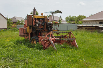 Old combine harvester in the village yard. Old agricultural machinery