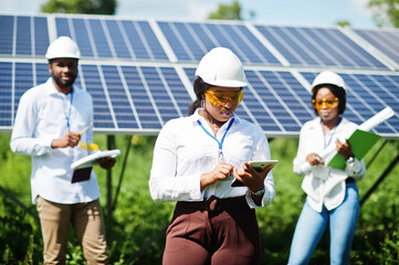 African american technician checks the maintenance of the solar panels. Group of three black...