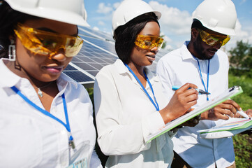 African american technician checks the maintenance of the solar panels. Group of three black...