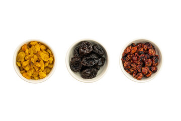 Top view of various kinds of dried fruit in white ceramic bowls on white background with clipping path.