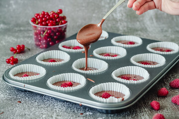 Spoon poured chocolate dough into muffin tins