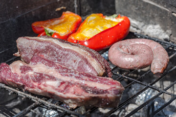 Closeup take of a traditional Argentinian and Uruguayan barbecue, Creole sausage, whit peppers and...