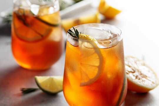 Traditional iced tea with lemon, lime and ice garnished with rosemary twigs.