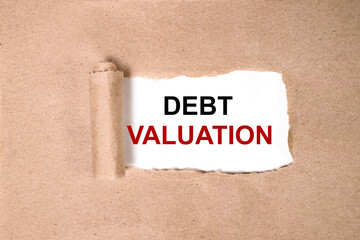 DEBT VALUATION. INSCRIPTION ON A WHITE BACKGROUND ON TORNED PAPER. CLOSE-UP