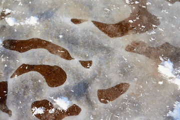 Testure or background with snow, ice and sand in a cold winter day outdoors. Nature landscape with frozen snow on a sandy beach or coast of lake or river in the cold and sun
