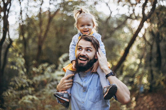 young, stylish bearded father walking with his little daughter in nature at sunset. Family photos of father and one child. selective focus, noise effect
