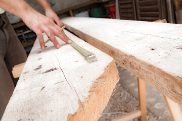 Male carpenter working on old wood in a retro vintage workshop.