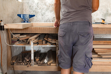 Male carpenter working on old wood in a retro vintage workshop.