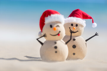 Two Sandy Christmas Snowmen are celebrating Christmas on a beautiful beach, one of them is only in focus