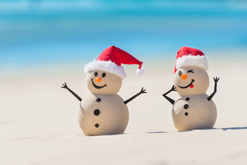 Two Sandy Christmas Snowmen are enjoying Christmas holidays on a beautiful beach, one of them is only in focus