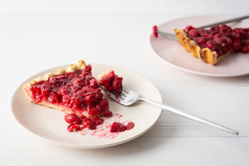 Cherry clafoutis on white background, plates with a portion of the pie and spoons