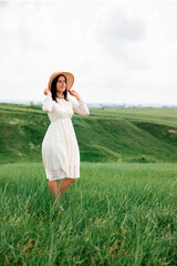 Young beautiful girl with dark hair in a dress outdoors.
Everything is green around. Happy girl. Environment concept, nature