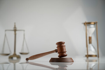 Law and justice concept. Scale, gavel and hourglass on off-white background.