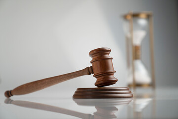 Law and justice concept. Scale, gavel and hourglass on off-white background.