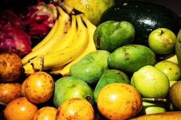 Close up of lots of exotic fresh ripe juicy fruits on wooden brown table background
